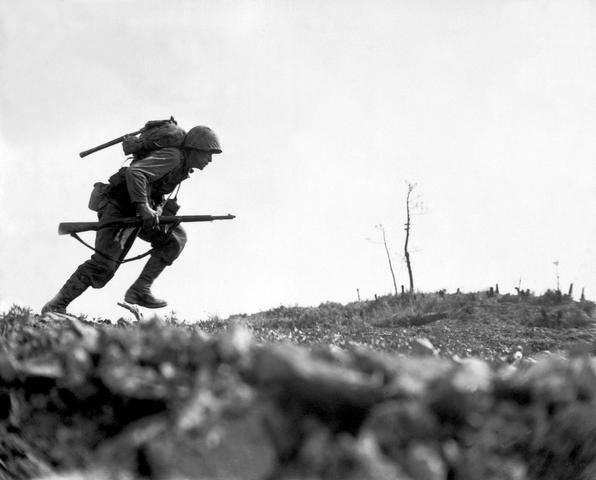 Szeregowiec Paul E. Ison z 1 Dywizji Marines biegnie przez Dolinę Śmierci na Okinawie, 10 maja 1945 roku (domena publiczna)