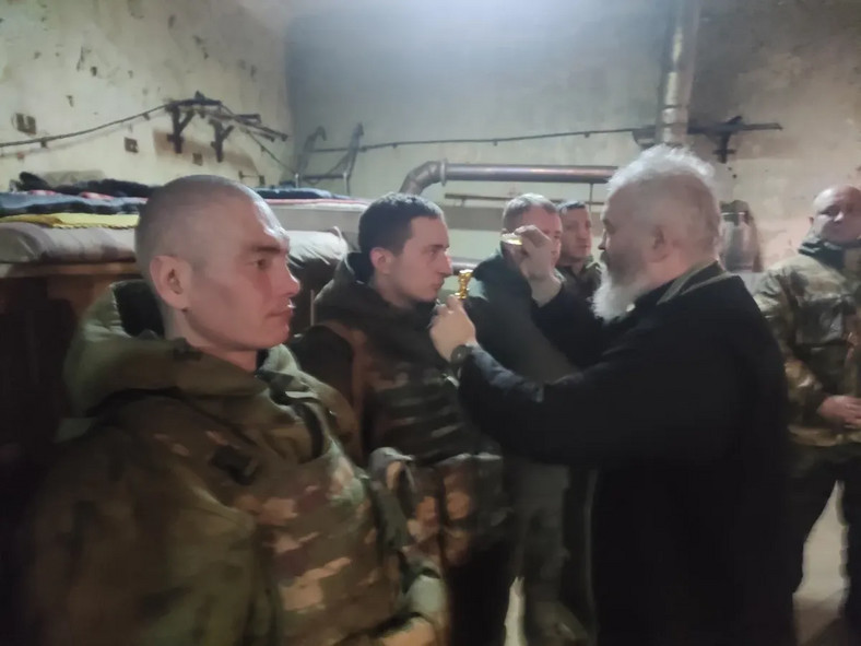 Ks. Dmitrij Wasilienkow błogosławi rosyjskich żołnierzy na froncie w Ukrainie