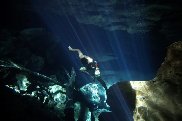 A worker of the cavern of Poco Azul (Blue well) dives to search for tourist dropped belongings, ahea