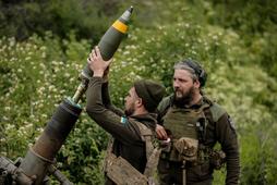 Ukraińscy żołnierze ładują pocisk moździerzowy na froncie w Donbasie