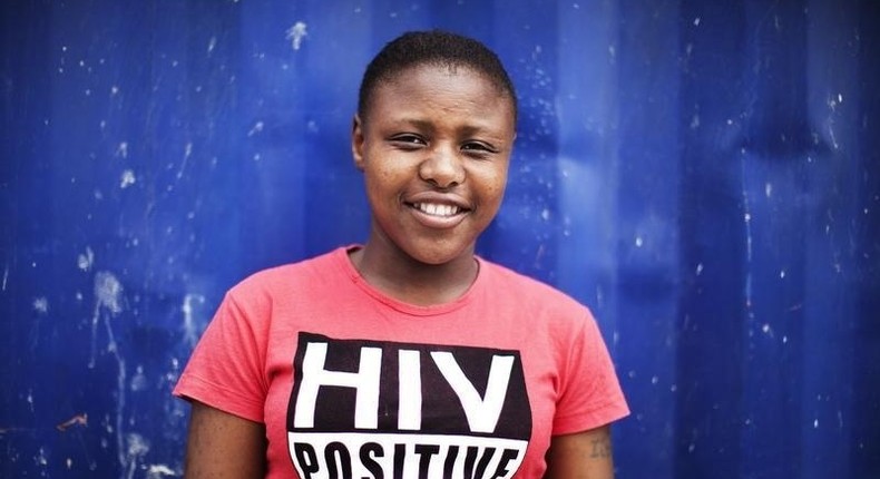 Nandi Makhele, 25, poses for a portrait while wearing a T-shirt indicating that she is HIV-positive, in Cape Town's Khayelitsha township, file. 