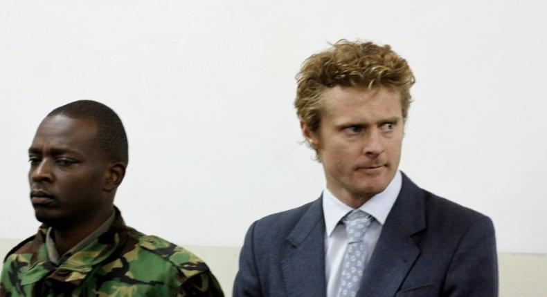 British national Jack Marrian (R), flanked by a police officer, appears in court in Nairobi on August 8, 2016, where he faces charges of trafficking 100 kilos of cocaine from Brazil to Mombasa 