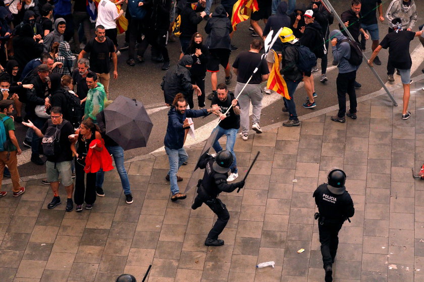 Passengers look as a police officer walks past at Barcelona's airport, during a protest after a verd