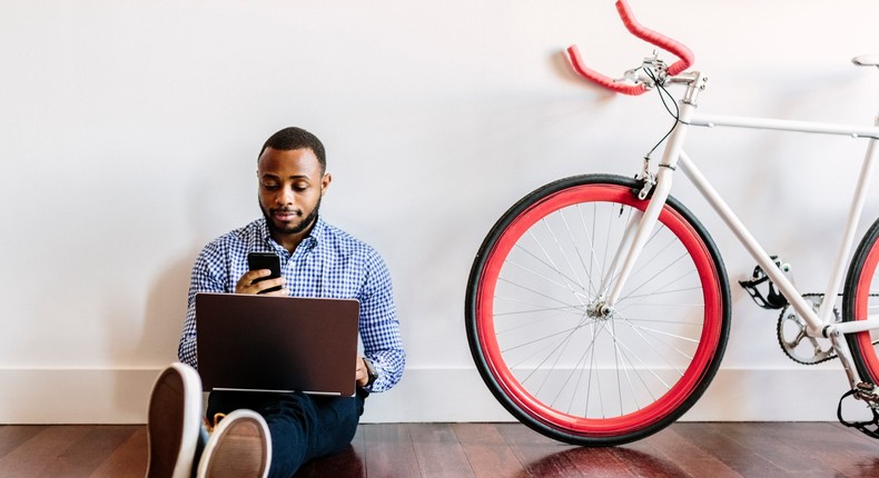 A man works from home next to a bicycle.
