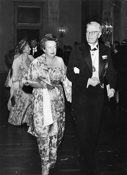Maria Goeppert-Mayer eskortowana przez króla Szwecji Gustawa Adolfa na uroczysty bankiet po ceremonii, podczas której otrzymała Nagrodę Nobla w dziedzinie fizyki. Domena publiczna