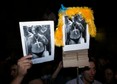 People hold images of Kaczynski, leader of the Law and Justice party, during clashes in Warsaw