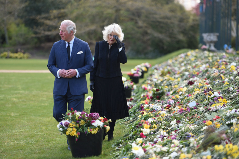 Księżna Camilla i książę Karol oglądają kwiaty pozostawione przez obywateli