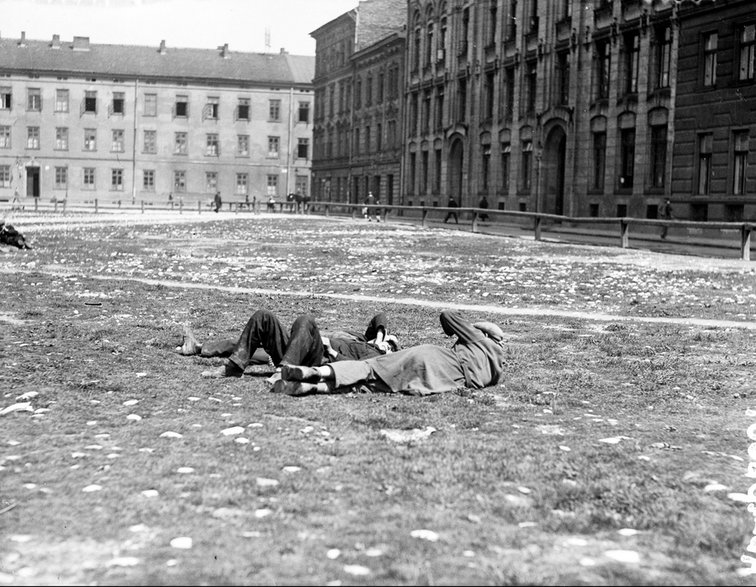 Bezrobotni mężczyźni leżący na trawie. Kraków, 1930 r. Źródło: Narodowe Archiwum Cyfrowe.