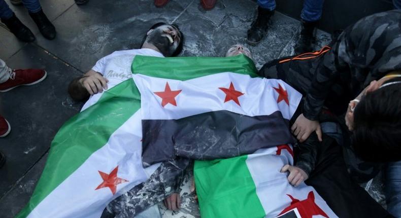 Protesters in Paris act out the role of victims of the April 2017 sarin gas attack, just days after scores died in the Syrian town of Khan Sheikhun