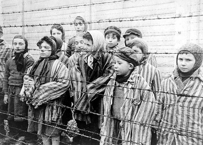 Dzieci za drutami obozu. Zdjęcie stanowi kadr z sowieckiego filmu dokumentującego wyzwolenie Auschwitz