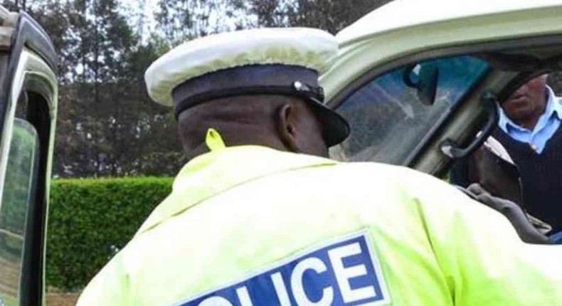 A traffic police officer inspects a matatu