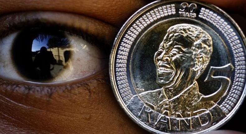 Nthombi Kwena holds a 5 rand coin minted to commemorate former South African president Nelson Mandela's 90th birthday in Johannesburg July 7, 2008. REUTERS/Juda Ngwenya