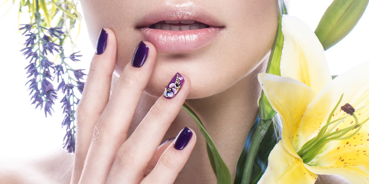 Beautiful girl with flowers, and design nails manicure. beauty face. Close up