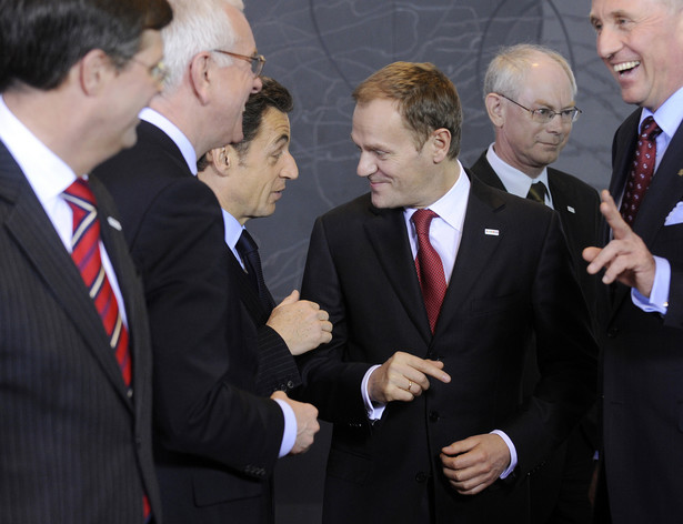 Premier Donald Tusk rozmawia na nadzwyczajnym szczycie w Brukseli z prezydentem Francji Nicolas Sarkozy, w otoczeniu innych liderów Unii Europejskiej. Fot. Bloomberg