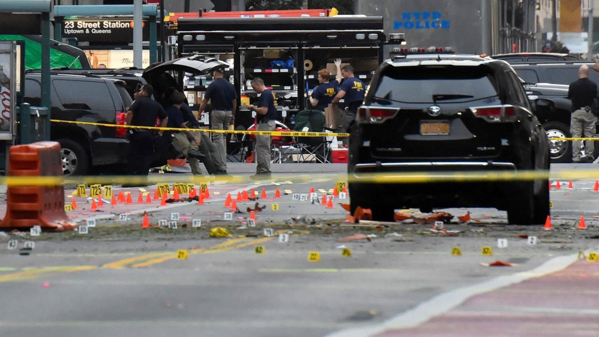 Evidence markers are seen on street around security officials near site of explosion in New York