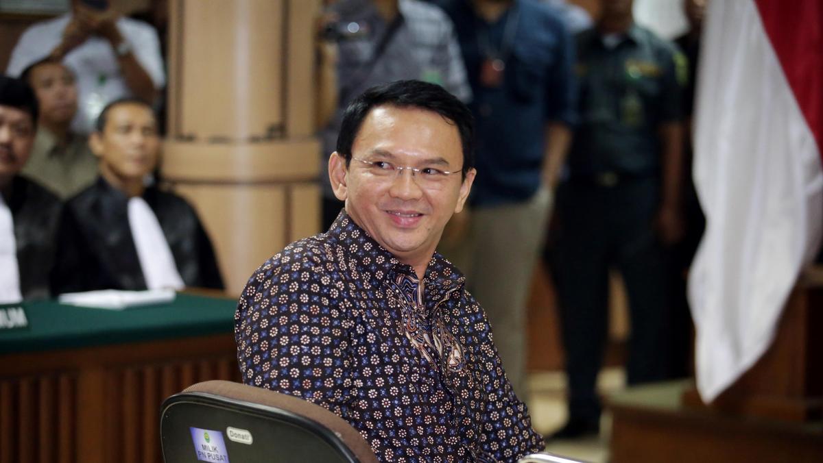 Jakarta's Governor Basuki Tjahaja Purnama smiles to the visitors inside the courtroom during his blasphemy trial at the North Jakarta District Court in Jakarta