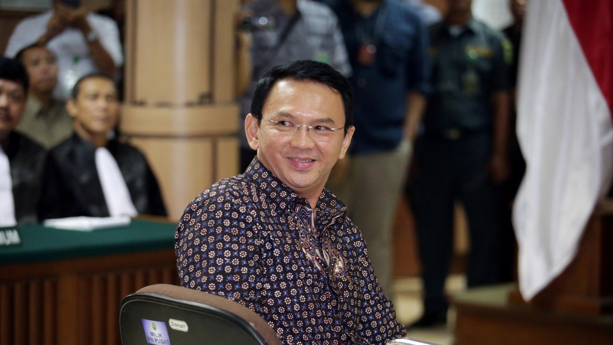 Jakarta's Governor Basuki Tjahaja Purnama smiles to the visitors inside the courtroom during his blasphemy trial at the North Jakarta District Court in Jakarta