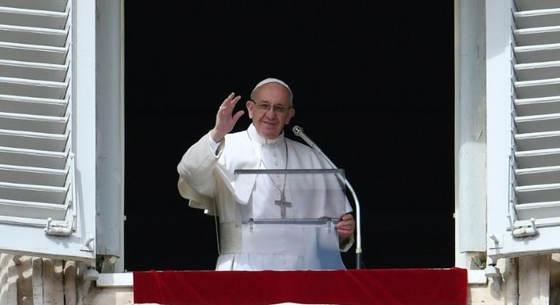 Pope Francis waves to the crowd from the window of the apostolic palace during the Sunday Angelus prayer at St Peter's square in Vatican