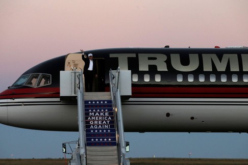 Republican presidential nominee Donald Trump waves as he walks off his plane at a campaign rally in 