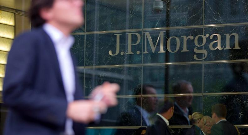 Workers are reflected in the windows of the Canary Wharf offices of JP Morgan in London September 19, 2013.