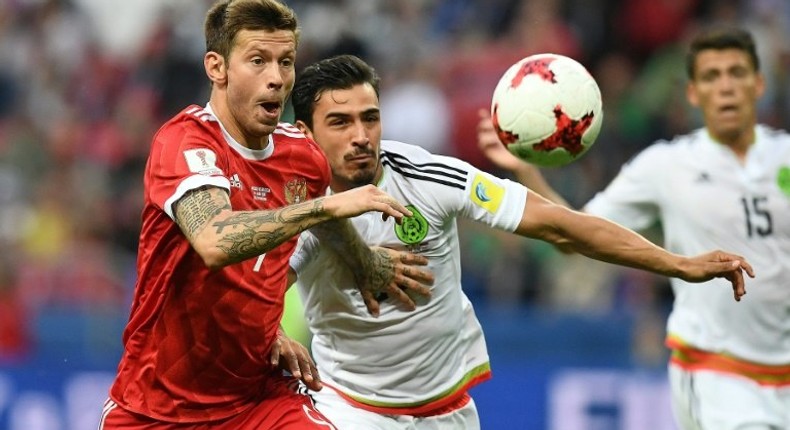 Russia forward Fedor Smolov (L) vies for the ball against Mexico defender Diego Reyes during the 2017 Confederations Cup group A match in Kazan on June 24, 2017