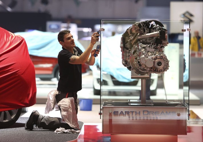 Przygotowania do targów Geneva Motor Show 2013. Mężczyzna czyści gablotę z silnikiem Hondy. Firma zapowiedziała, że zaprezentuje koncept Civica w wersji kombi, a także prototyp kolejnej generacji wersji NSX.