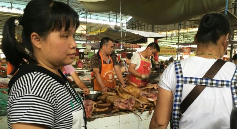 Vendors stand behind a pile of dog meat at the Nanqiao market in Yulin