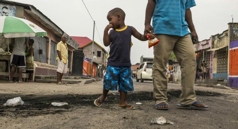 A child stares at the marks of burnt tyres following a protest in the Lingwala neighborhood in Kinshasa on December 20, 2016