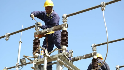 A Kenya Power employee working on a power line