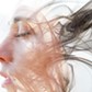 Double exposure portrait of a young fair-skinned woman and a smoky texture dissolving into her facial features