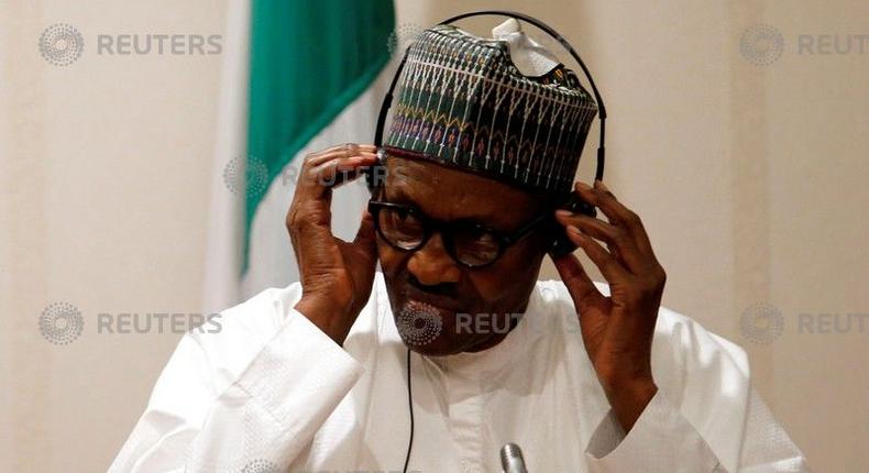 Nigeria's President Muhammadu Buhari adjusts his translation device during a news conference at the presidential villa in Abuja, Nigeria, August 31, 2018. 