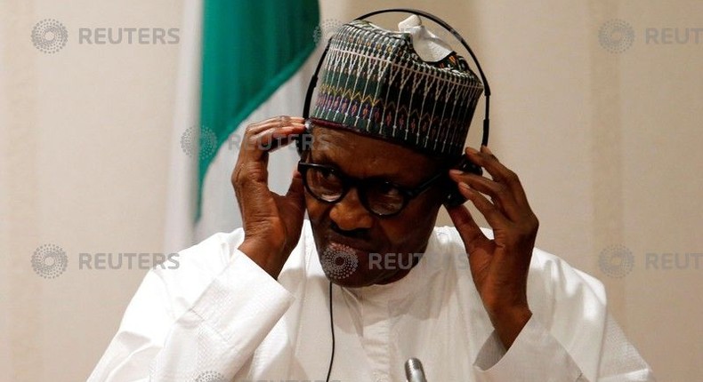 Nigeria's President Muhammadu Buhari adjusts his translation device during a news conference at the presidential villa in Abuja, Nigeria, August 31, 2018. 