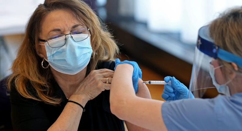 A file photo shows a woman receiving a COVID-19 vaccine.
