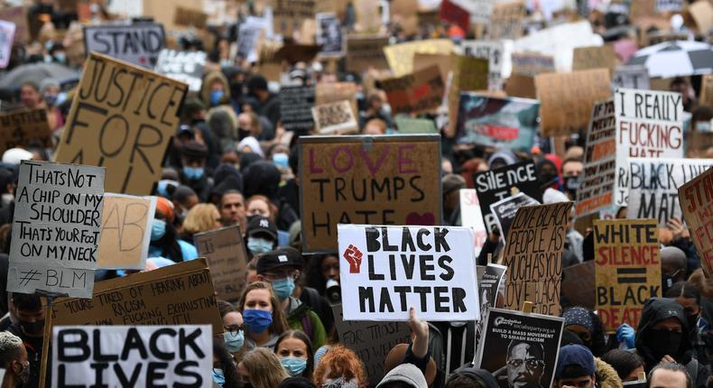 Protesters hold placards as they attend a demonstration in Parliament Square in central London on June 6, 2020, to show solidarity with the Black Lives Matter movement in the wake of the killing of George Floyd, an unarmed black man who died after a police officer knelt on his neck in Minneapolis.
