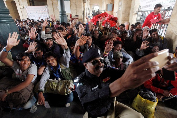 Fishermen from India who were held captive for crossing territorial waters wave for a selfie at Cant