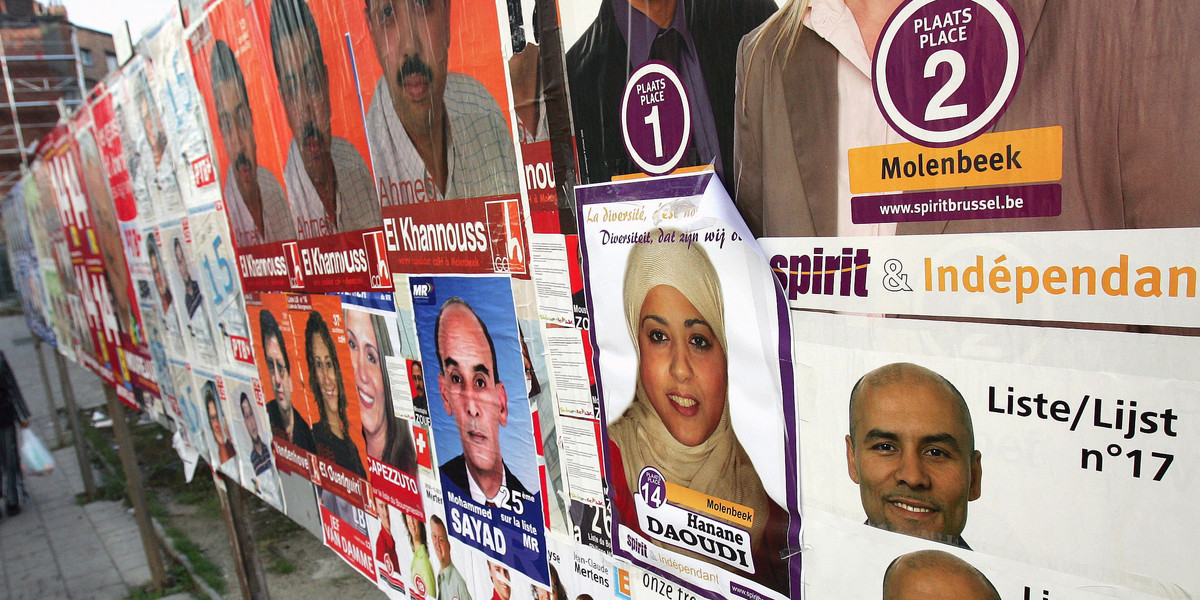 A woman walks past election posters in Molenbeek, one of the Brussels nineteen communes October 5, 2006.