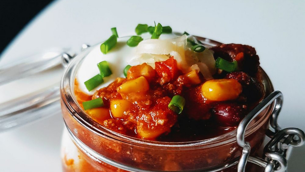 Ta wersja chili con carne z całymi ziarnami fasoli, kukurydzy i ostrą kiełbaską chorizo na pewno przypadnie wam do gustu. W towarzystwie śmietany, żółtego sera i szczypiorku. Wersji tego dania jest cała góra, a ta jest spośród nich chyba najprostsza. Chili con carne jest bardzo aromatyczne i oczywiście odpowiednio pikantne. A wy macie swoją ulubioną wersję chili?