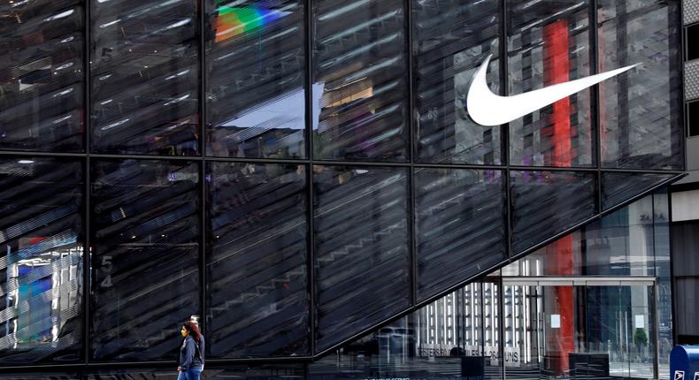 FILE PHOTO: People wearing protective face masks walk past the closed Nike store on a nearly empty 5th Avenue, during the outbreak of the coronavirus disease (COVID-19), in Manhattan, New York city, New York, U.S., May 11, 2020. REUTERS/Mike Segar