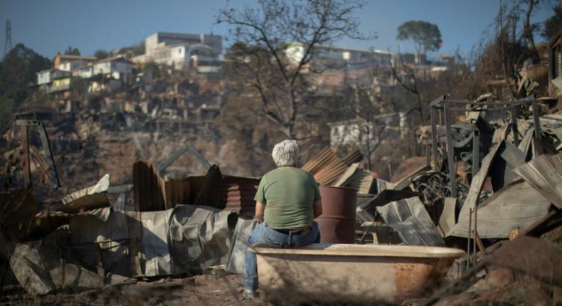 A man looks at the destruction caused by a forest fire on Rocuant hill in Valparaiso, Chile, on December 25, 2019