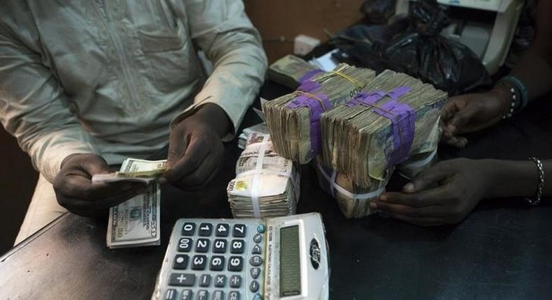 A trader changes dollars with naira at a currency exchange store in Lagos February 12, 2015. 