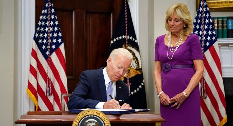 President Joe Biden signs into law the Bipartisan Safer Communities Act gun safety bill at the White House on June 25, 2022. First lady Jill Biden looks on at right.