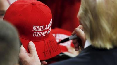 U.S. Republican presidential candidate Trump signs a hat at a campaign rally in West Chester