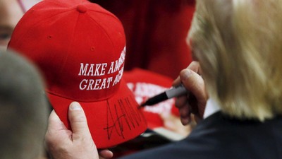 U.S. Republican presidential candidate Trump signs a hat at a campaign rally in West Chester