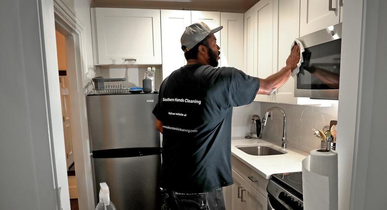 A Southern Hands Cleaning employee works inside a short-term rental in Boston.