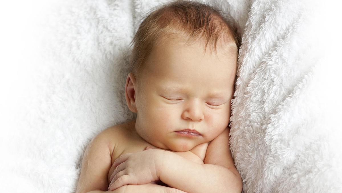 newborn baby sleeping on a white blanket