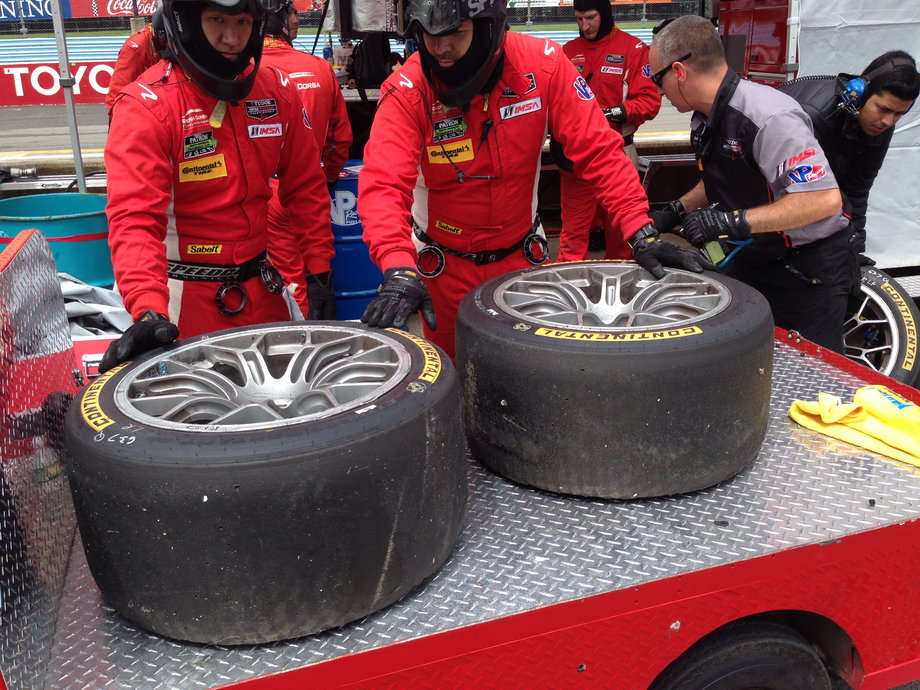 The pit crew inspects a set of tires after one of the cars experienced a brush with the wall. Tire wear can indicate whether there's something more serious wrong with a damaged car.