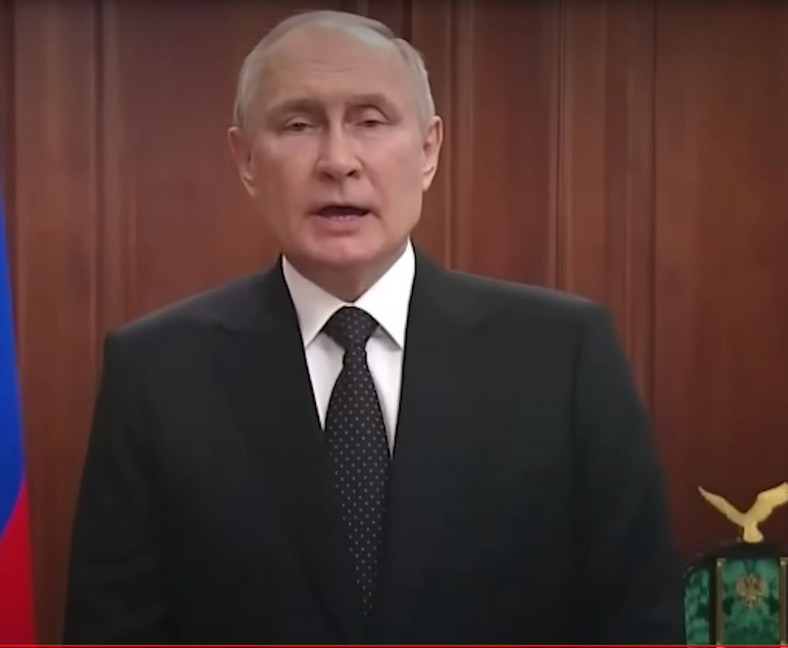 Władimir Putin ujęty, gdy lekko odchyla się, wzdycha i łapie powietrze.