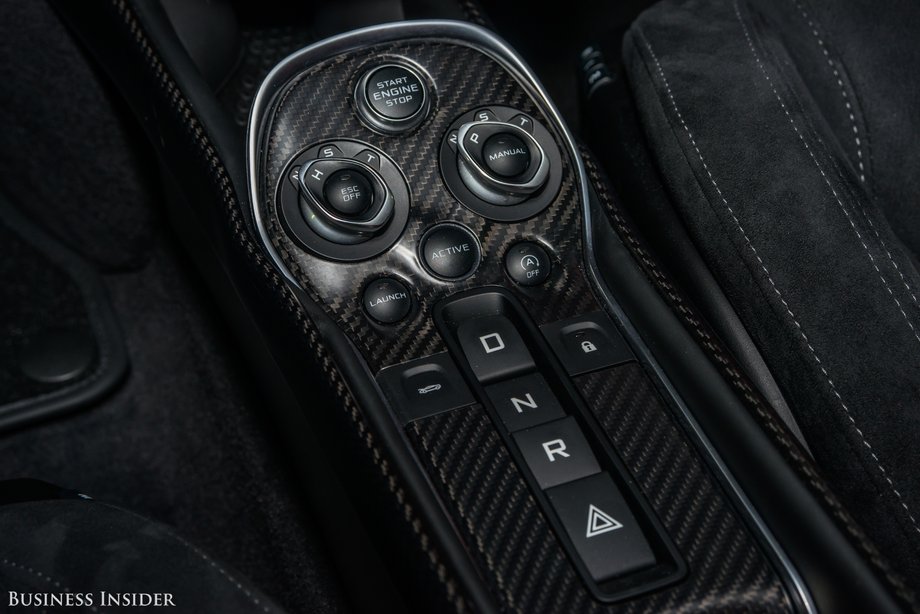 The center console houses the car's ignition switch, push button gear selector, and dynamic drive mode selector.