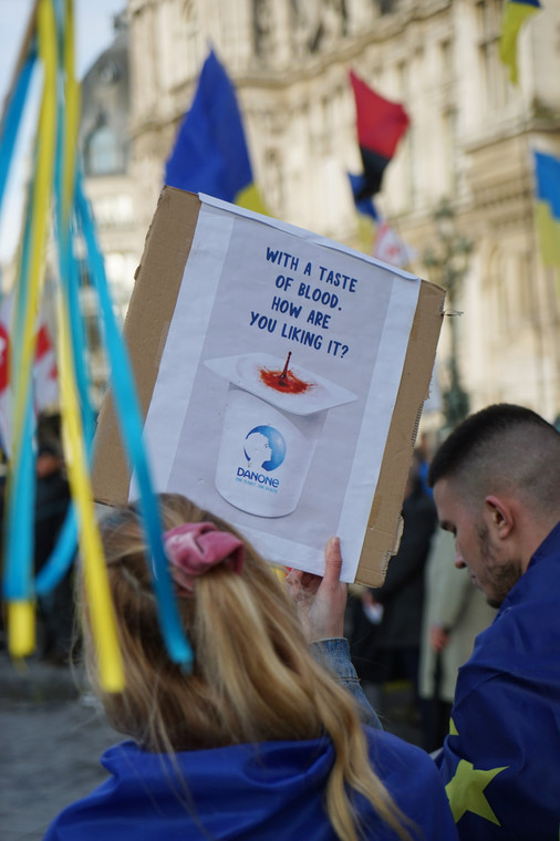 Protest przeciwko rosyjskiej inwazji na Ukrainę. "Jak ci smakuje z dodatkiem krwi?" brzmiał plakat trzymany przez jedną z uczestniczek, nawiązujący do tego, że firma Danone nie wycofała się z Rosji, Paryż, 2022 r.