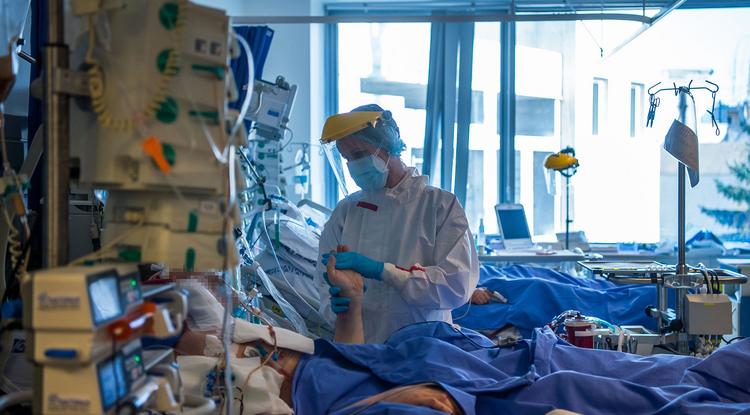 Védőfelszerelést viselő gyógytornász átmozgat egy beteget a fővárosi Semmelweis Egyetem Városmajori Szív- és Érgyógyászati Klinika koronavírussal fertőzött betegek fogadására kialakított intenzív osztályán 2021. április 9-én.